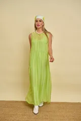 Vestido largo sin mangas de color verde lima, confeccionado en tela fluida y ligera, con escote redondo y corte amplio.