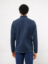 Buzo de micropolar azul con medio cierre frontal, cuello alto y bolsillo con cierre en el pecho. Presenta el logo de Umbro y el escudo del Club Nacional de Football.