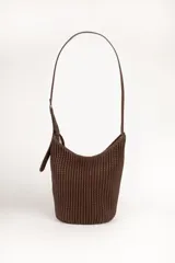 Cartera tipo hobo de color negro, con diseño plisado en toda su superficie y correa ajustable con hebilla metálica. Presenta una placa metálica decorativa en la parte inferior frontal.