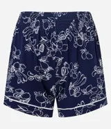 Pijama de dos piezas compuesto por una blusa de manga corta con cuello y cierre de botones, y un short con cintura elástica. El conjunto es de color azul marino con un estampado integral de flores y frutas en blanco, con ribetes blancos en los bordes.
