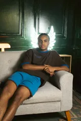 Remera oversize marrón con cuello y mangas con ribete azul. Estampado en la espalda con diseño de alfajores y texto en azul.