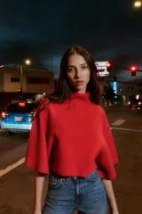 Jersey de punto liso en color gris, con cuello subido y mangas anchas de corte holgado. Presenta acabados en rib en el cuello y los puños.
