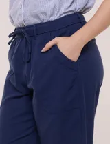 Pantalón capri de algodón a rayas verticales en tonos azul, celeste y blanco, con cintura elastizada, cordón de ajuste frontal y bolsillos aplicados.