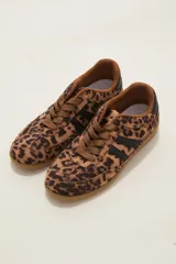 Zapatillas urbanas con estampado animal print de leopardo, cordones al tono y detalles de franjas laterales en color negro. Presentan suela de goma color caramelo y cuello acolchado.