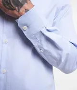 Camisa de vestir blanca de algodón con textura maquinetada, cuello camisero y mangas largas.