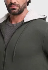 Canguro verde militar con capucha forrada en piel sintética color crema, cierre frontal con cremallera, bolsillos tipo canguro y puños y cintura acanalados.