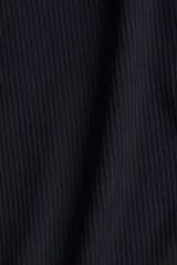 Remera polo de manga larga, color azul marino oscuro, confeccionada en tejido de punto acanalado. Presenta cuello clásico y tapeta frontal con botones dorados.