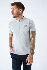 Polo gris con textura diferenciada, fit regular, logo estampado, con cierre y manga corta.