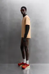 Camiseta deportiva color naranja confeccionada en tejido técnico, ligero y elástico. Tiene cuello redondo, mangas cortas y logo estampado.