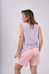 Conjunto de pijama sin mangas, compuesto por un top con cuello en V y ribete en contraste, y un short con cintura elástica. El top es de color lila con estampado floral y el short es de color rosa.