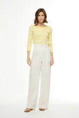 Pantalón de vestir blanco de corte palazzo, con bolsillos laterales y dos bolsillos tipo cargo con solapa a la altura de la rodilla.