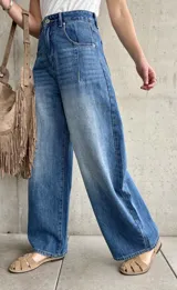Jean de denim azul de tiro alto, con silueta barrel de corte ancho y relajado.