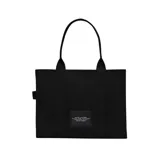 Bolso tote de gran tamaño Marc Jacobs, confeccionado en lona de algodón negra con el logo estampado en blanco en el frente. Cuenta con asas superiores reforzadas y una estructura amplia y resistente.