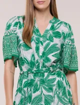 Vestido midi de estilo bohemio en color verde y blanco, con estampa floral, escote en V, cierre frontal con botones, mangas cortas amplias, cintura ajustable con lazo y volado en el bajo.
