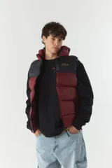 Chaleco puffer color borgoña y negro, con capucha y cuello alto.