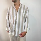 Camisa de lino a rayas verticales color beige y blanco, con cuello mao y mangas largas con puños abotonados.