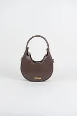 Cartera mini hobo estructurada de cuero negro, decorada con arandelas metálicas doradas en toda la superficie. Cuenta con asa corta de mano y correa de cadena metálica extraíble.