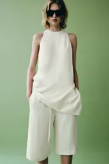 Top de Zara Woman Collection color blanco, confeccionado con mezcla de lino, con cuello redondo, espalda nadadora y diseño de bajo asimétrico.