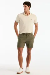 Short de lino color verde militar, de corte recto, con cintura elástica ajustable mediante cordón y bolsillos laterales.