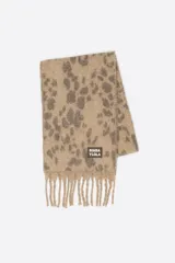 Bufanda de tejido cepillado con estampado de leopardo en tonos beige y gris, con flecos en los extremos y etiqueta con logo de la marca.