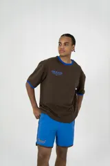 Short deportivo azul con ribete marrón y logo bordado en el muslo.