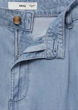 Pantalon wide leg de denim suave, color azul claro, con tiro medio, cierre frontal de cremallera y botón, detalle de pinzas y bolsillos laterales.