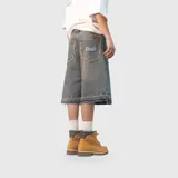 Bermuda de jean estilo baggy con lavado desgastado, corte holgado y largo por debajo de la rodilla. Presenta bordes deshilachados en los bolsillos traseros y en el ruedo, con el logo de la marca bordado en el bolsillo trasero derecho.