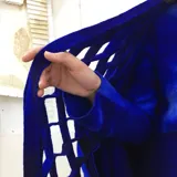 Capa azul de lana merino afieltrada, con guarda tejida en cuello y ruedo. Se puede usar como poncho o como capa abierta.