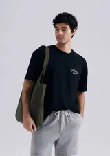 Camiseta negra de manga corta con estampa pequeña en el pecho.