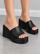 Sandalias de plataforma alta y taco chino, color negro, con faja ancha superior y diseño destalonado.