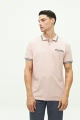 Remera polo azul marino de manga corta, con cuello y puños a rayas blancas y verde militar. Presenta un bolsillo en el pecho con detalle de franja a rayas y el logo de la marca "Brooksfield" bordado en dorado.