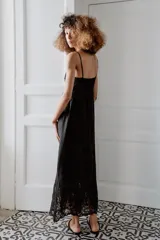 Vestido midi negro con escote en pico, tirantes finos y detalles de bordados y encaje en el escote y el bajo.