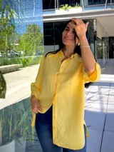Camisa de manga corta color amarillo, con cuello clásico y botones frontales.