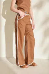 Pantalón azul marino de corte wide leg con detalles en tono marrón tostado en la cintura, bolsillos y bordes laterales, cuenta con trabillas para cinturón y cierre frontal.