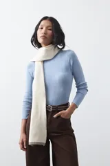 Polera de tejido de punto con textura calada y diseño de líneas verticales acanaladas. Presenta cuello alto y mangas largas con puños delicados, de silueta entallada.