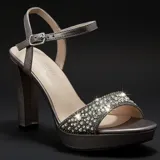 Sandalias de tacón alto en color peltre, con plataforma delantera y tira frontal decorada con pedrería brillante. Cuenta con cierre de pulsera con hebilla ajustable al tobillo.
