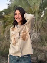 Camisa color beige de tejido de punto fino con apliques de cuero en cuello, hombros y bolsillos.