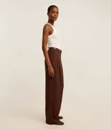 Blusa sin mangas de corte regular, confeccionada en tejido rib de algodón con cuello redondo. Presenta un diseño minimalista y anatómico, ideal para un look clásico.