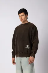 Buzo de cuello redondo con efecto desgastado, de calce oversize y mangas largas. Presenta un pequeño logo estampado en la parte inferior frontal y una etiqueta pequeña en el puño.