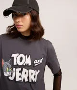 Remera de algodón color gris oscuro con cuello redondo y manga corta. Presenta un estampado grande con el logo de "Tom and Jerry" en blanco y los personajes Tom y Jerry.