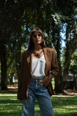 Blazer de corte sastrero con diseño de rayas verticales finas, solapas clásicas y bolsillos frontales con solapa. Presenta un calce holgado y estructura definida.