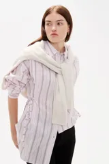 Camisa de viscosa con estampado de rayas verticales, cuello camisero, cierre frontal con botones y detalle de lazos laterales para entallar la cintura.