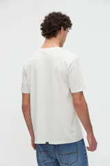 Remera de manga corta color blanco con estampa tipográfica frontal en tono rojo, de calce clásico y cuello redondo.