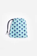 Short de baño celeste con estampado de hojas pequeñas en tonos verdes y blancos. Cuenta con cintura elástica con cordón ajustable, bolsillos laterales y un parche circular con logo en la parte inferior.