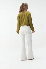 Jean flare de color blanco con costuras en contraste y diseño de tiro medio.