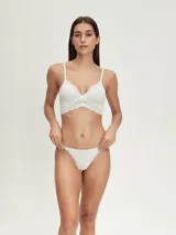 Colaless de tiro bajo color negro, con bordes de encaje floral en la parte delantera y trasera. Los laterales son tiras finas ajustables con argollas metálicas.