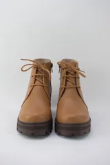 Borcego color suela de cuero con plataforma tractorada, cordones y cierre lateral.
