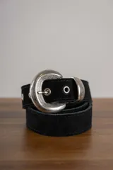 Cinturón negro de cuero gamuzado con hebilla plateada con diseño.