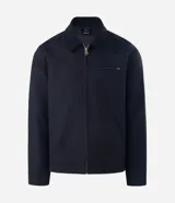 Campera tipo trucker de sarga color azul marino, con cuello de terciopelo al tono, cierre frontal de cremallera y bolsillo con cierre en el pecho.