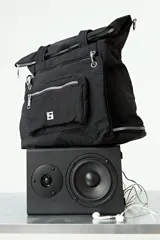 Mochila shopper de color negro, confeccionada en poliéster. Presenta un diseño multifuncional con correas ajustables y removibles que permiten usarla como mochila, cartera cruzada o de hombro. Incluye un compartimento inferior extensible mediante cierre y un bolsillo frontal removible que funciona como estuche independiente.
